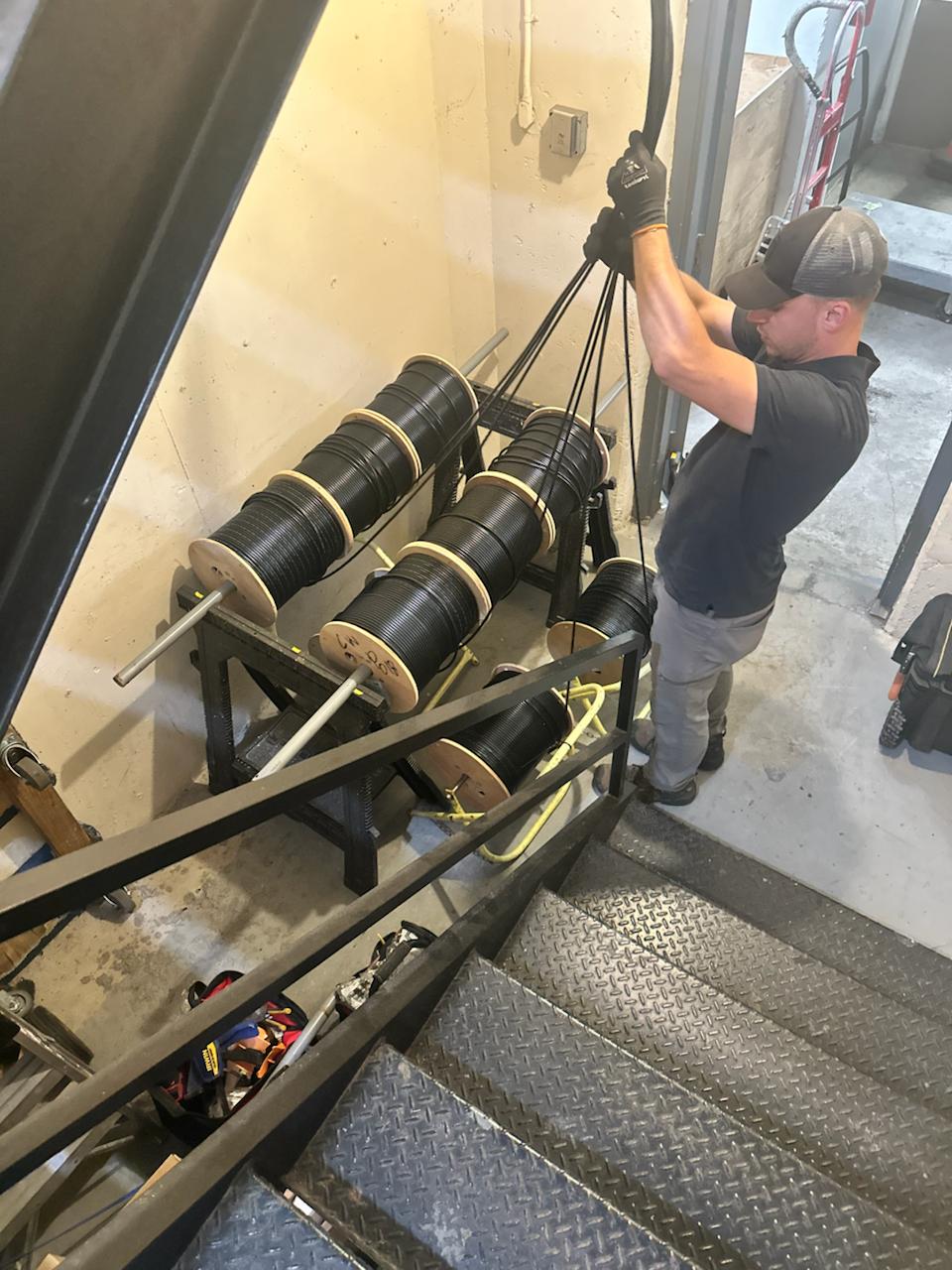 InterConnect technician pulling fiber from cable reels in an MDU